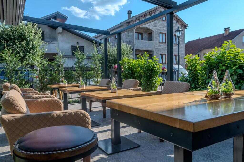 Covered outdoor terrace with wooden tables